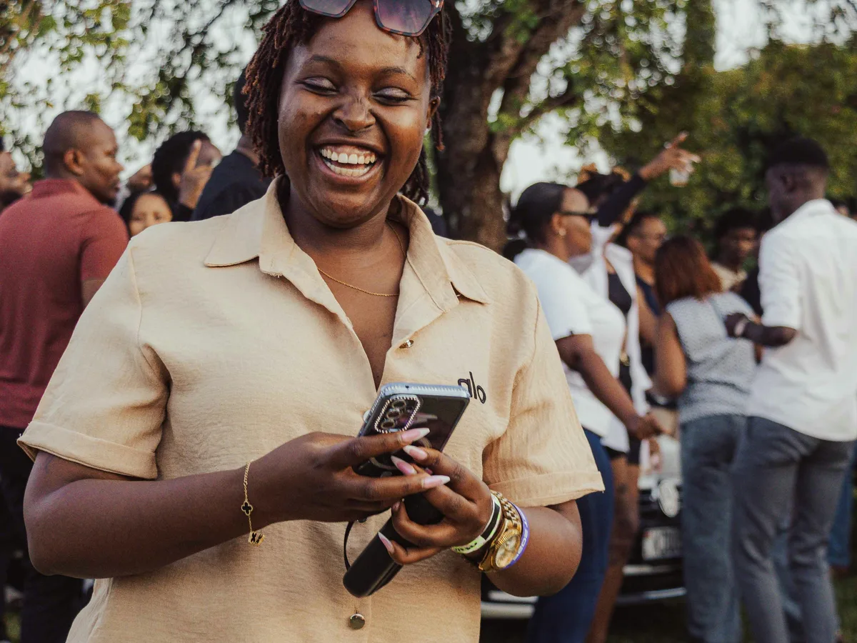 A woman laughing at an outdoor community gathering
