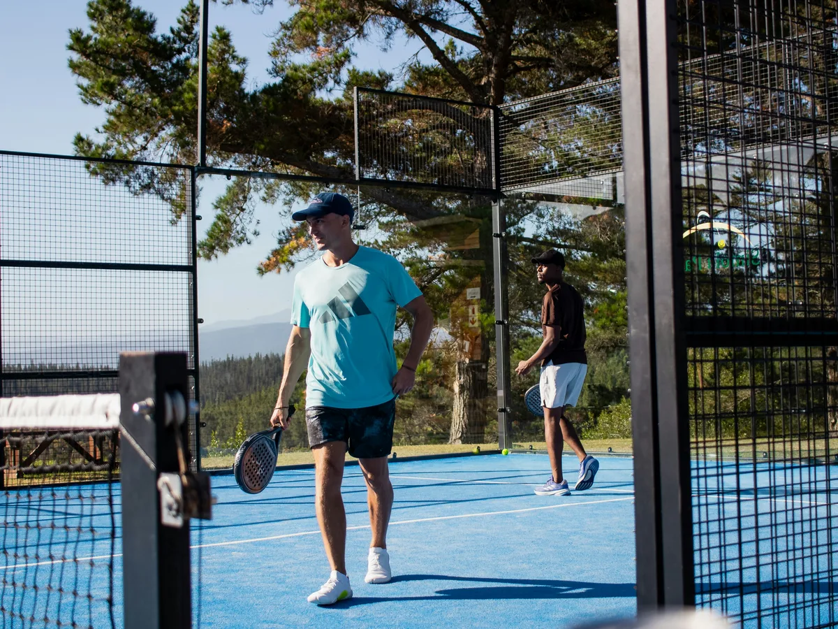 Two people playing pickleball on an outdoor court